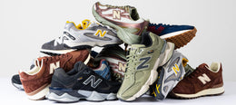 Stacked selection of New Balance trainers in mixed colourways featuring suede and mesh uppers with cushioned soles.