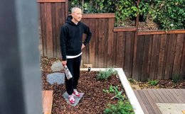 Jason Markk holding a newspaper standing in his Garden