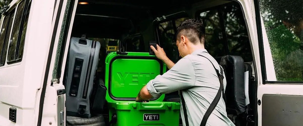 Man Opening Green Yeti Cooler at Back of Van