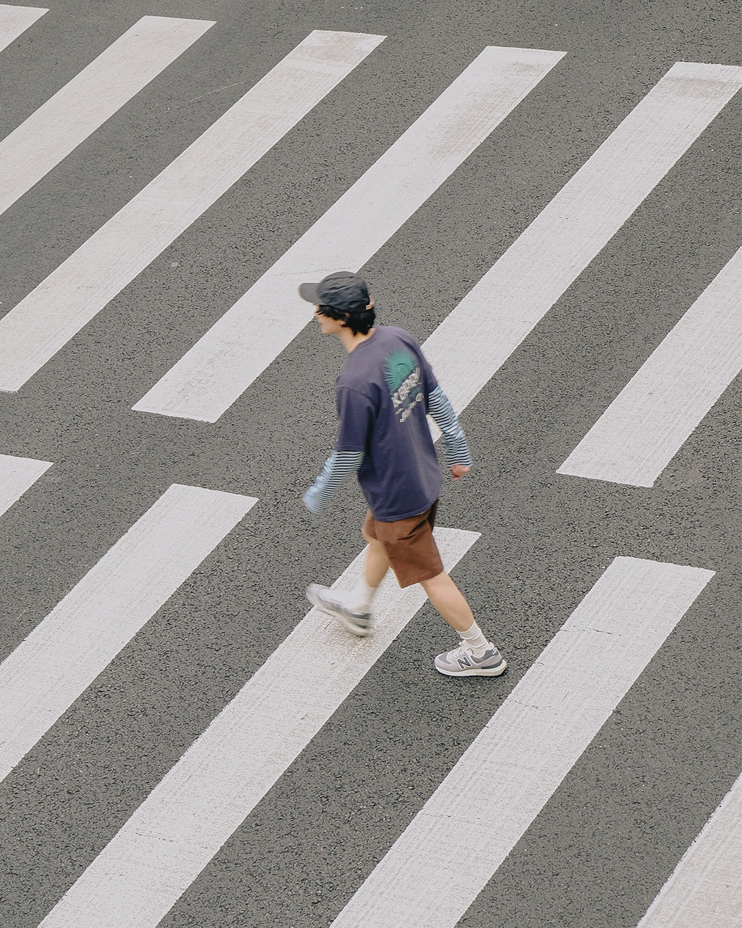 Man Wearing Kappy Streetwear Clothing Crossing a Road