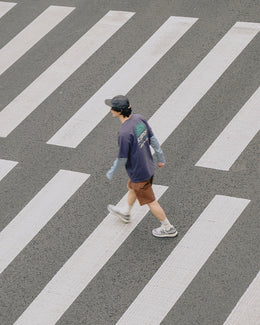 Man Wearing Kappy Streetwear Clothing Crossing a Road