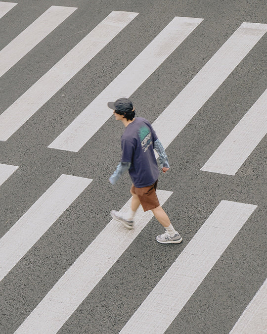 Man Wearing Kappy Streetwear Clothing Crossing a Road