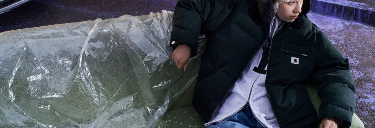 Person sat wearing a Carhartt jacket on a sofa