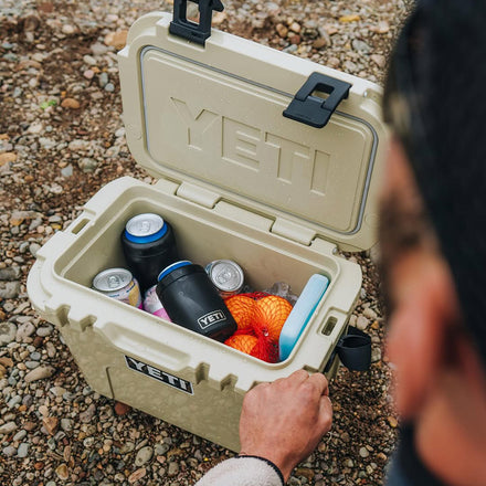 YETI cooler with food and drinks on a rocky ground